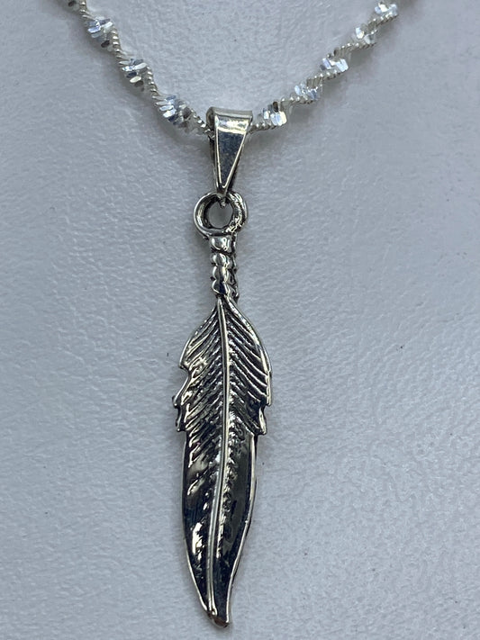Dije de pluma en plata .925 tallado a mano, mostrado en cadena de eslabones espiral