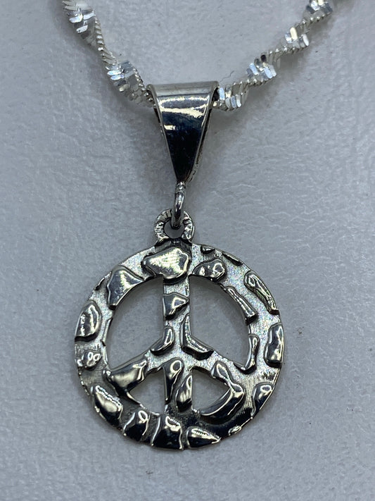Dije símbolo de paz en plata .925 granulado de Taxco, 2 cm de largo