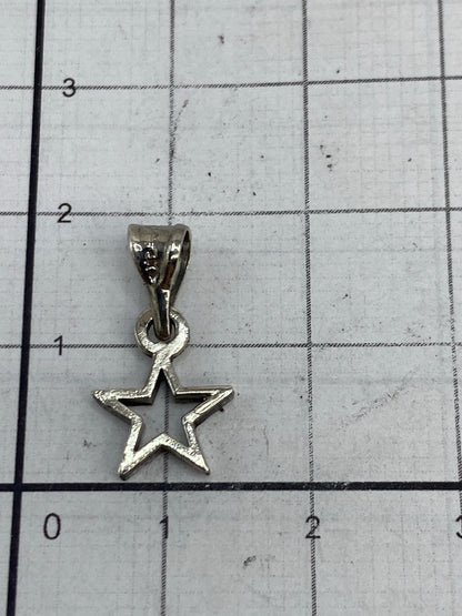 Dije de estrella en una báscula mostrando 0.7 gramos