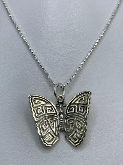 Detalle del patrón prehispánico en el dije de mariposa con repujado a mano