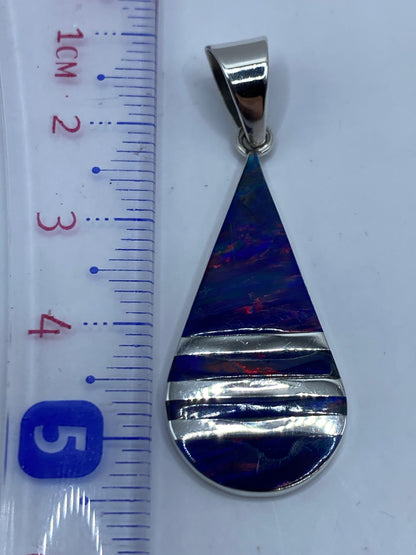 Dije de plata con Quinto .950 grabado en el reverso, sobre fondo blanco