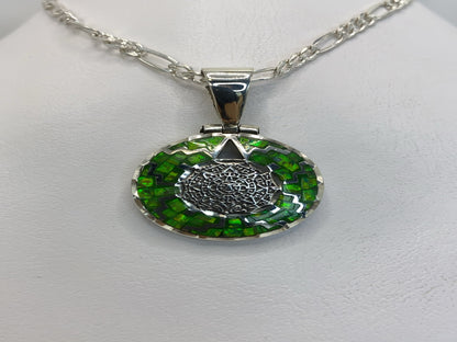 Dije de plata .950 con Ópalo de Fuego verde y diseño prehispánico, colgando de una cadena plateada