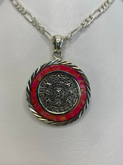 Detalle frontal del Calendario Azteca y el engaste manual del ópalo de fuego en tonos rosa y dorado