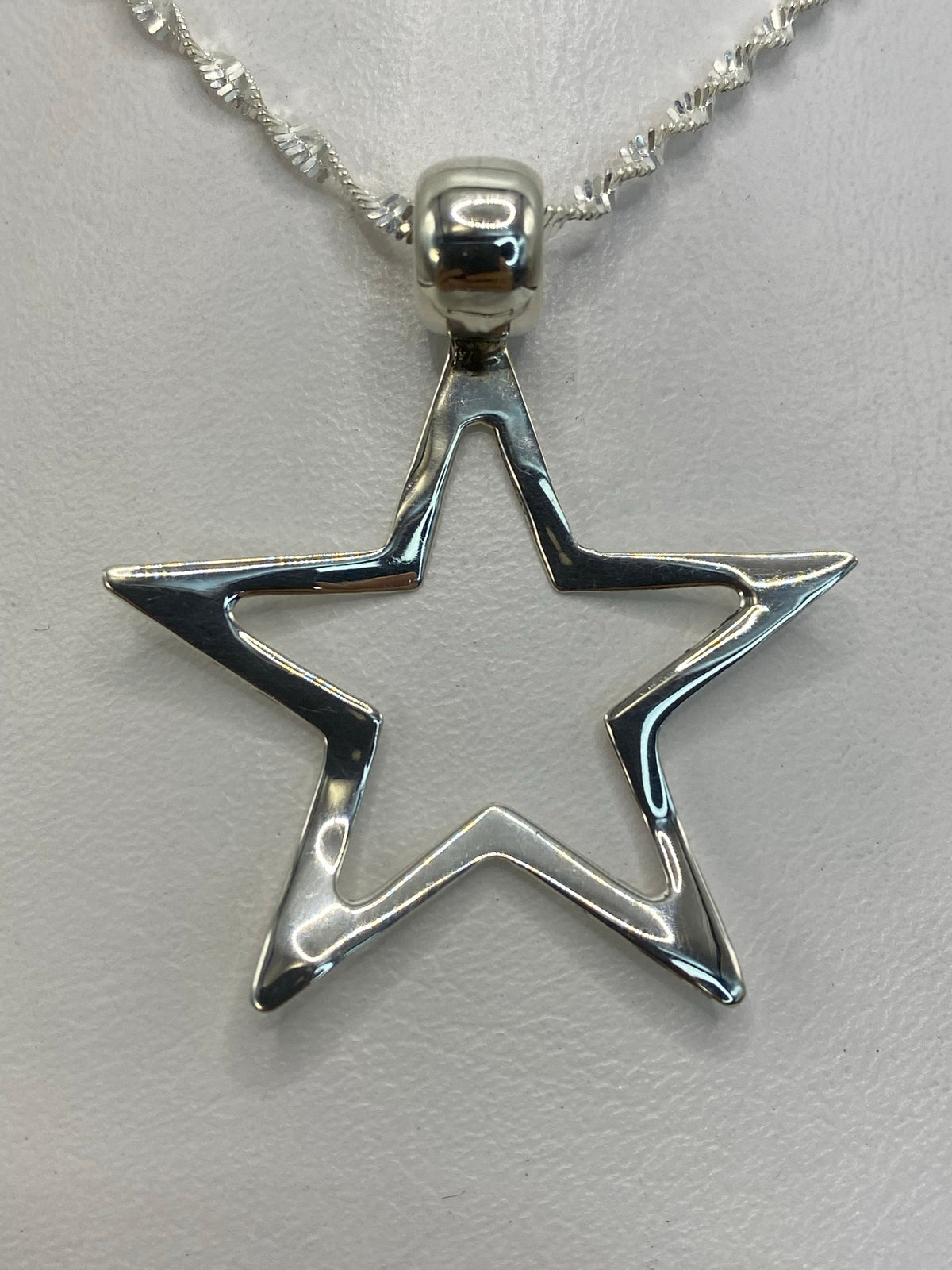 Dije de plata estrella minimalista de 4 cm, colgando de cadena plateada