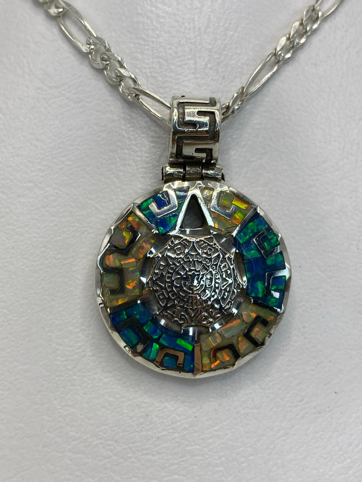 Dije de plata 950 con ópalo azul visto al trasluz, mostrando los destellos de fuego