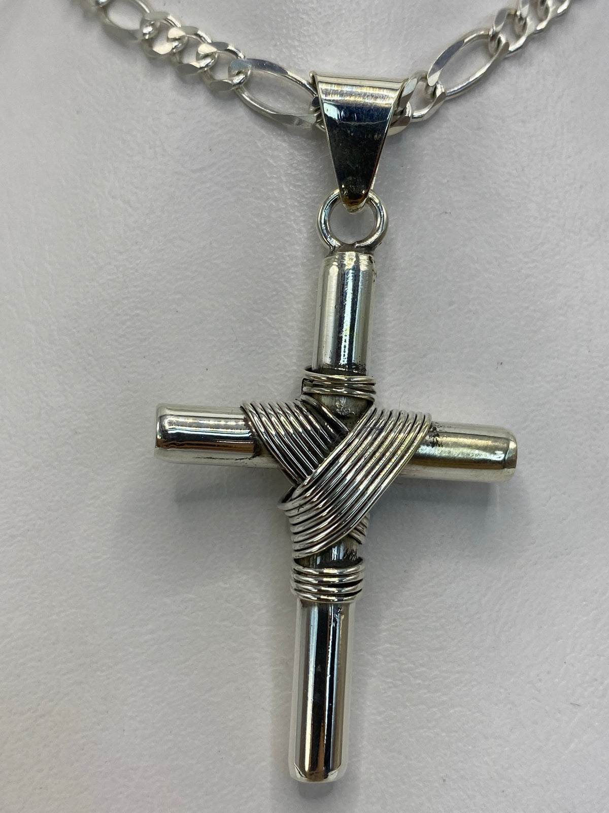 Dije cruz de plata 925 con enrollado artesanal en la intersección, vista frontal