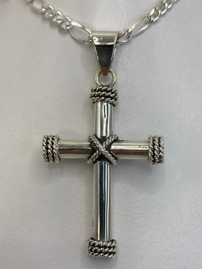 Dije cruz de plata 925 colgando de una cadena figaro, vista frontal