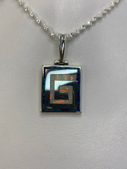 Dije de plata 950 con ópalo de fuego blanco en diseño geométrico cuadrado, colgado en cadena de plata