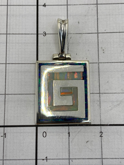 Reverso del dije con el Quinto 950 gravado, sobre fondo blanco