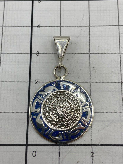 Dije Calendario Azteca sobre escala de gramos mostrando su tamaño real de 3.5 cm