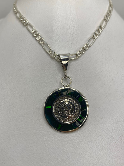 Detalle del dije prehispánico: relieves del calendario azteca en plata y ópalo verde engastado