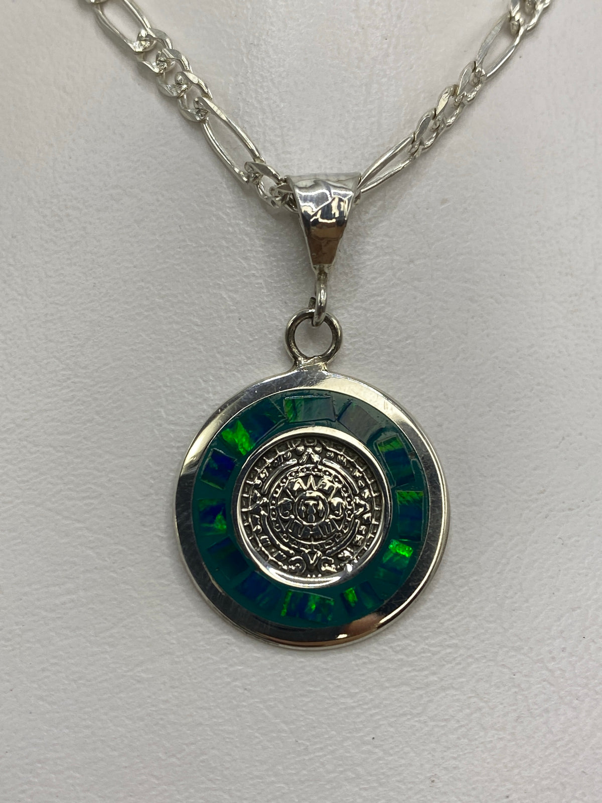 Dije de plata con calendario azteca y ópalo de fuego verde en el cuello