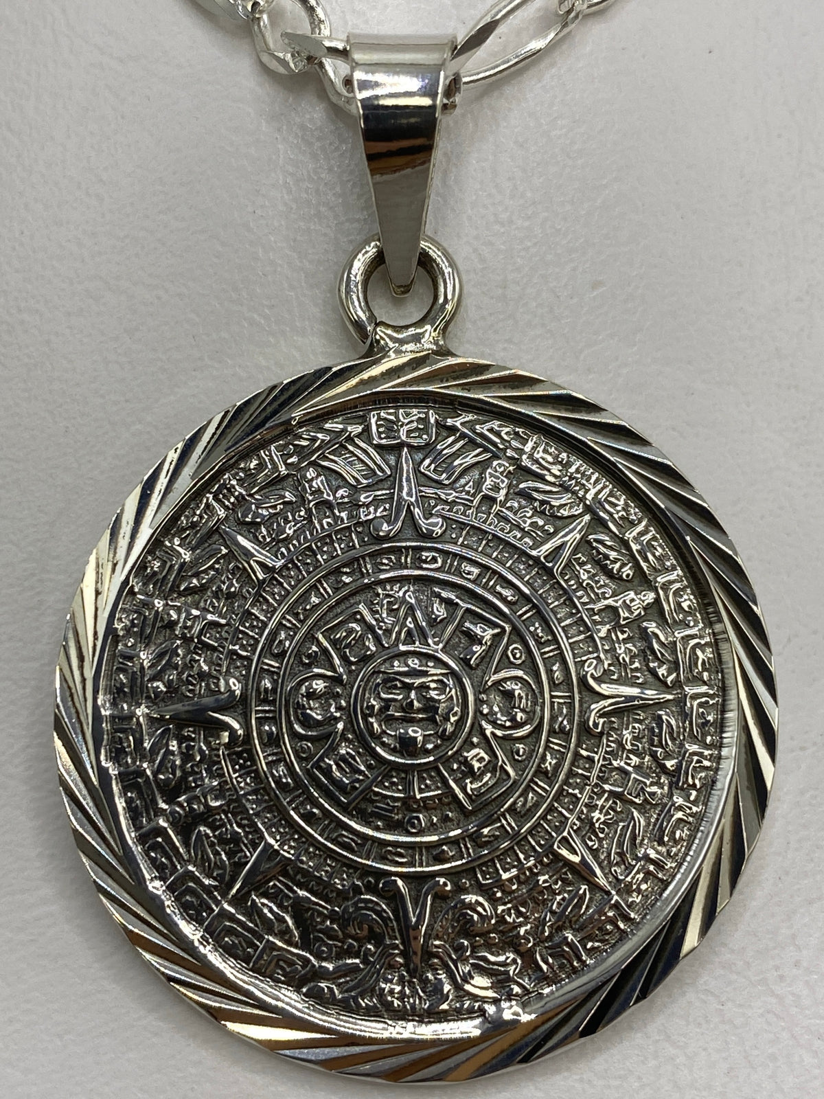 Dije de plata sobre regla métrica mostrando 5 cm de largo