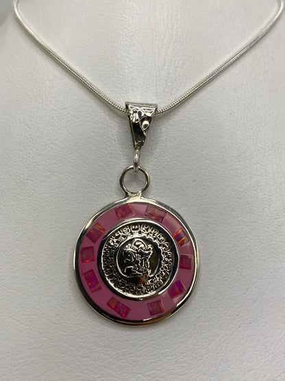 Detalle del diseño calendárico grabado y la piedra ópalo en tono rosa