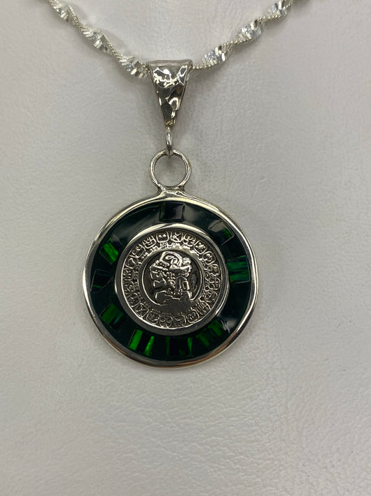 Dije de plata con calendario azteca y ópalo de fuego verde, colgando de cadena de plata retorcida