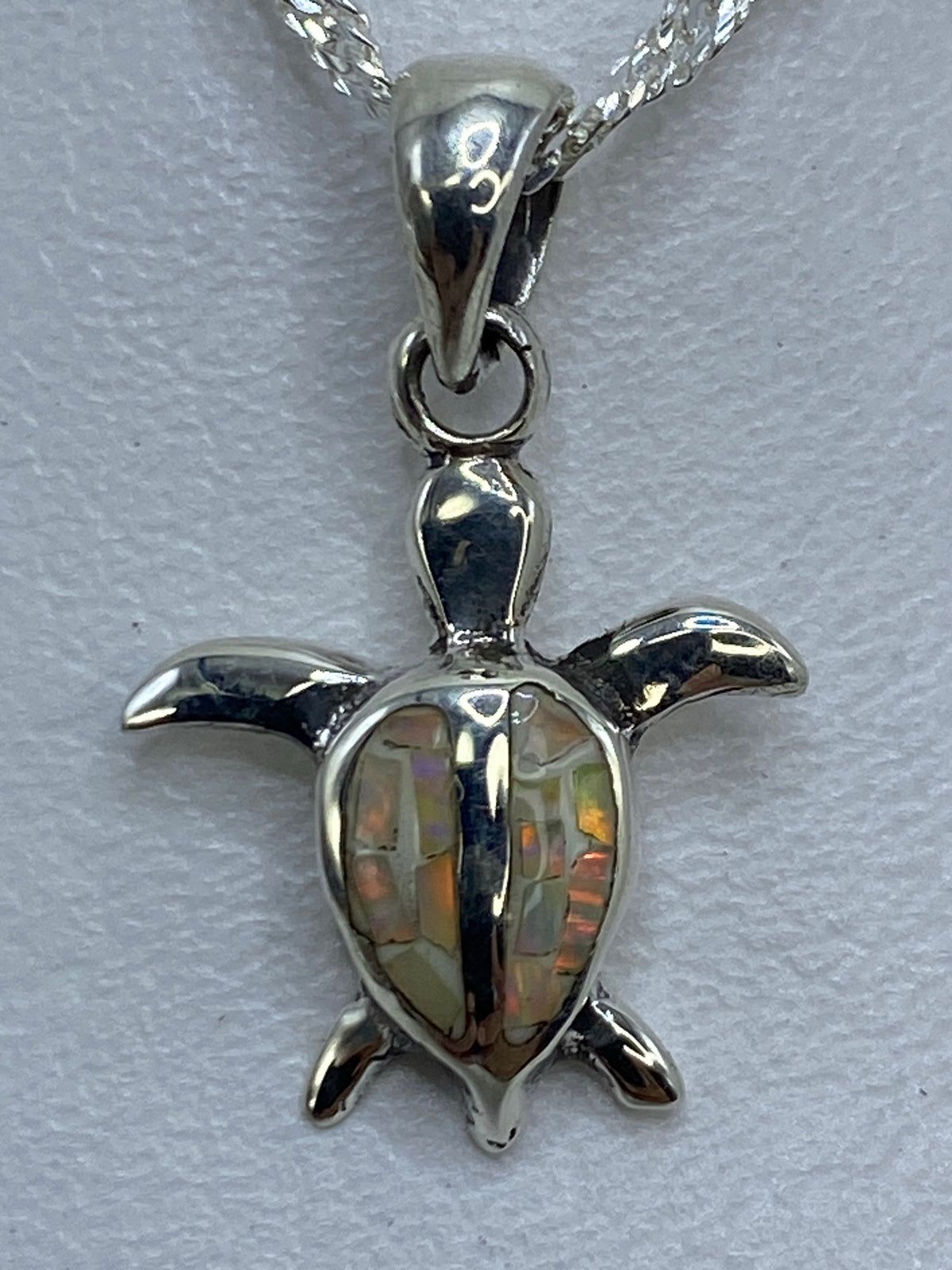 Vista frontal del dije tortuga de plata pura de Taxco, 2 cm de largo