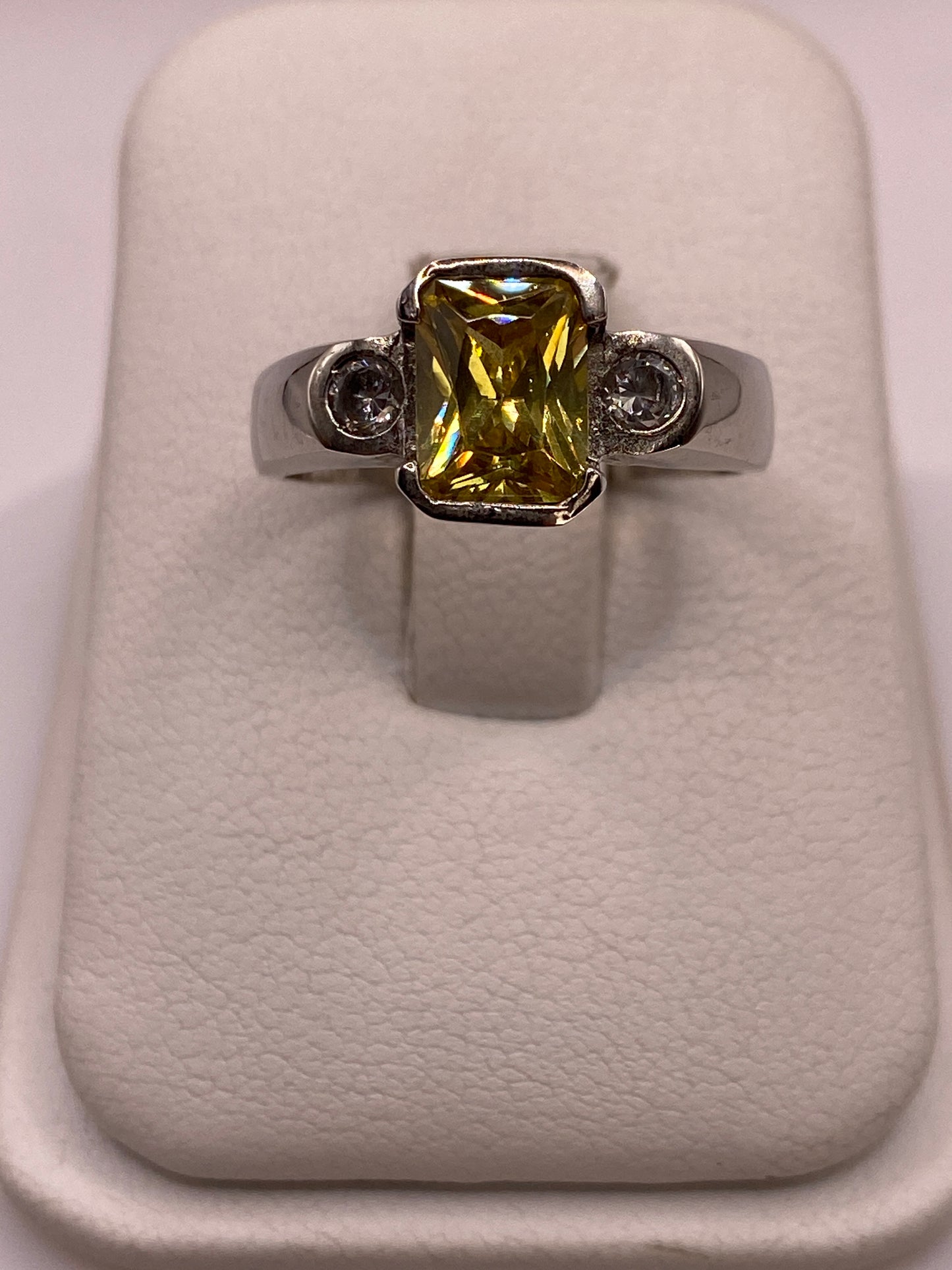 Anillo de plata con circonia amarilla en la mano de una mujer, mostrando el brillo del solitario