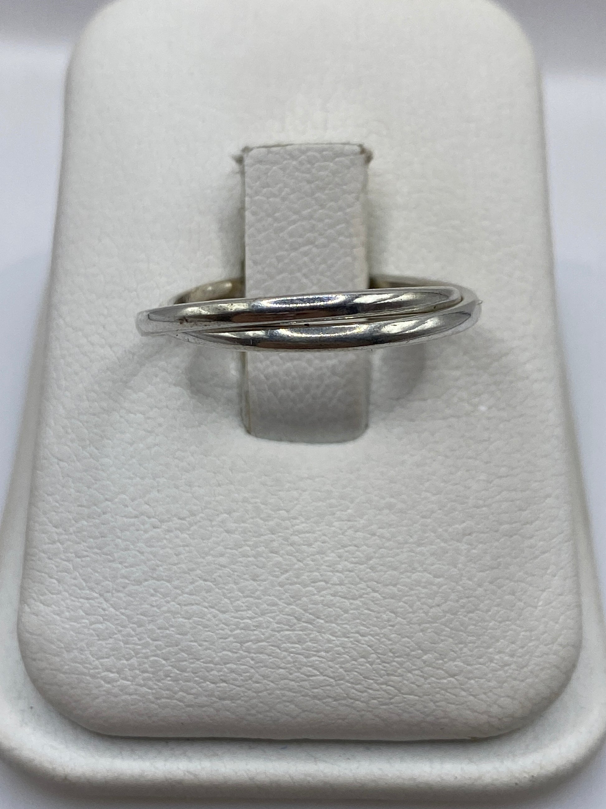 Anillo de plata banda doble pulida en la mano de una mujer, mostrando el brillo espejo