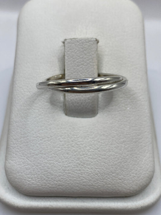 Anillo de plata banda doble pulida en la mano de una mujer, mostrando el brillo espejo