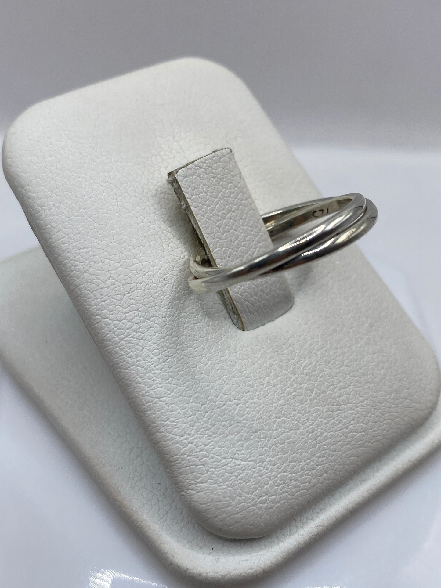 Vista frontal del anillo minimalista de dos bandas entrelazadas en plata .925