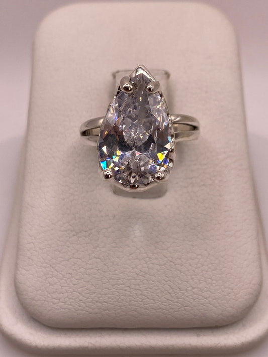 Anillo solitario de plata .925 con circonia pera blanca glacial vista desde arriba sobre portaanillos blanco