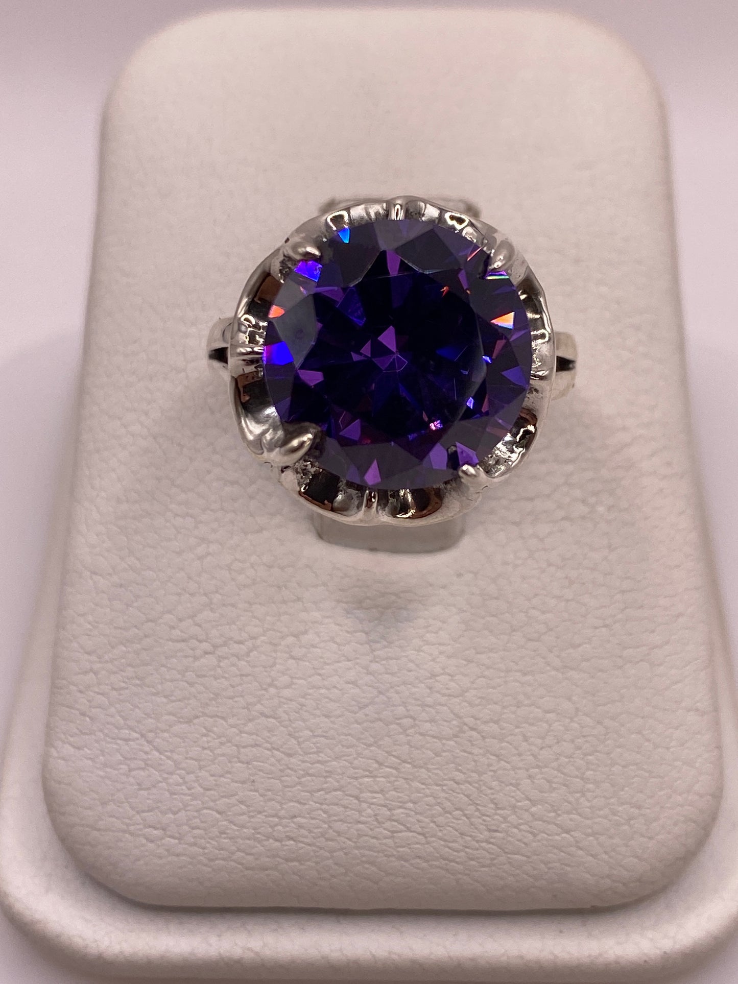 Anillo solitario de plata .925 con circonia redonda color violeta intenso en engaste de garras ornamentadas, vista cenital