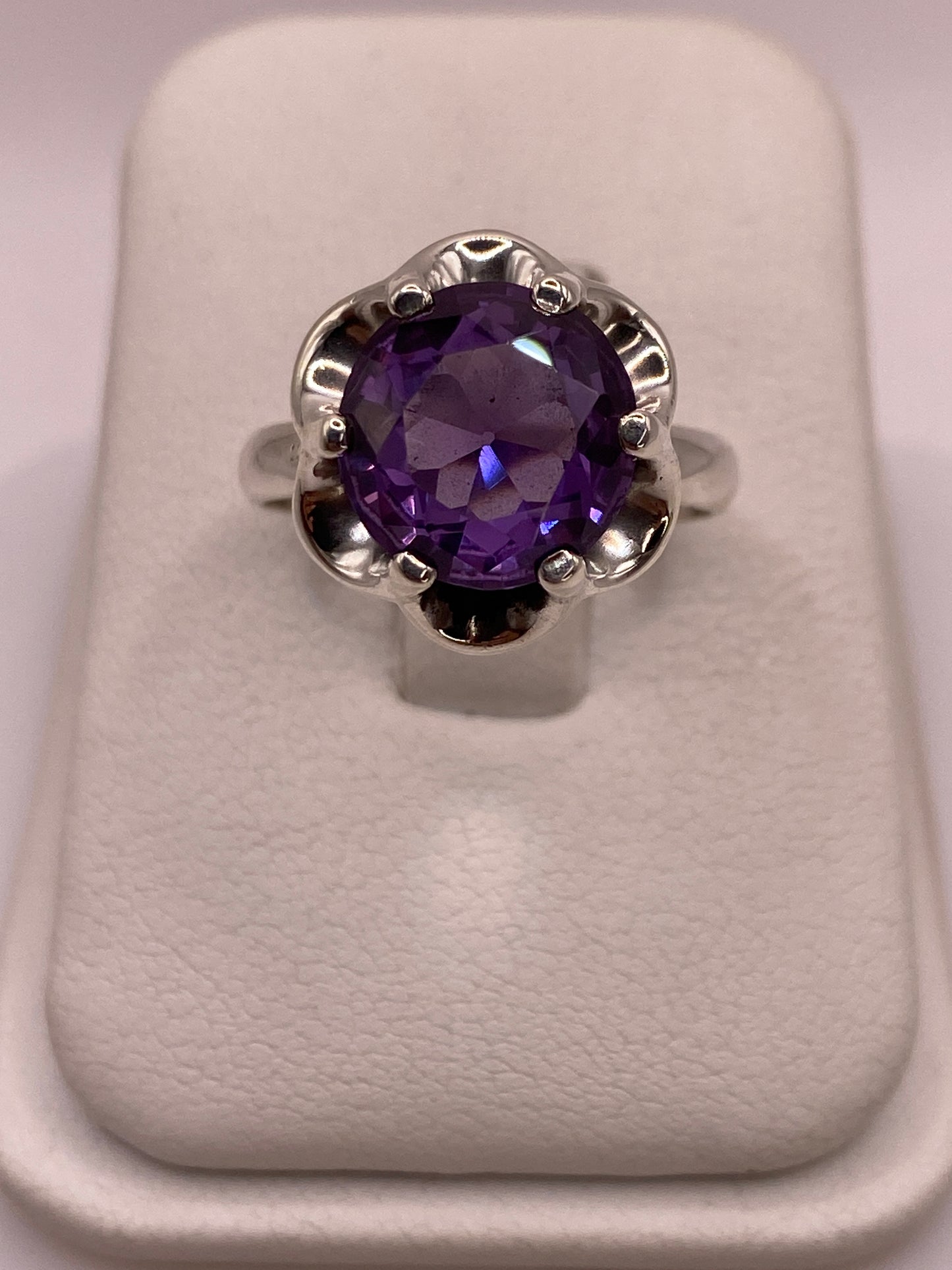 Anillo solitario de plata .925 con circonia oval morada intensa en montura floral calada, vista superior