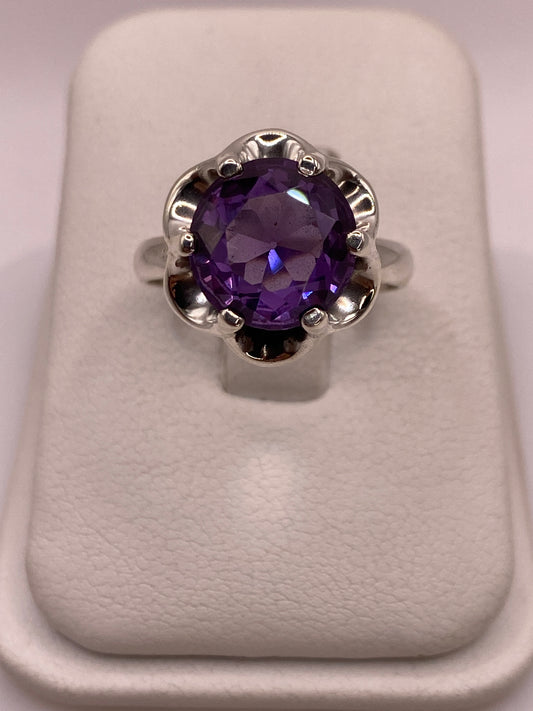 Anillo solitario de plata .925 con circonia oval morada intensa en montura floral calada, vista superior