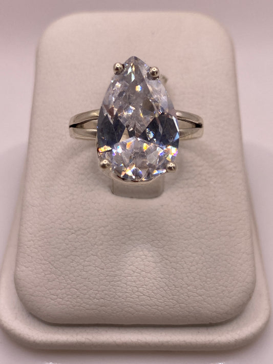Anillo solitario de plata con circonia pera blanca en mano de mujer, brillo diamantado intenso