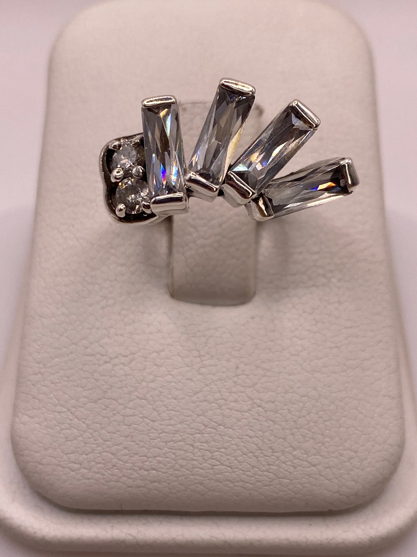 Anillo solitario de plata con circonia gris ahumado en talla baguette sobre dedo de mujer con manicura natural