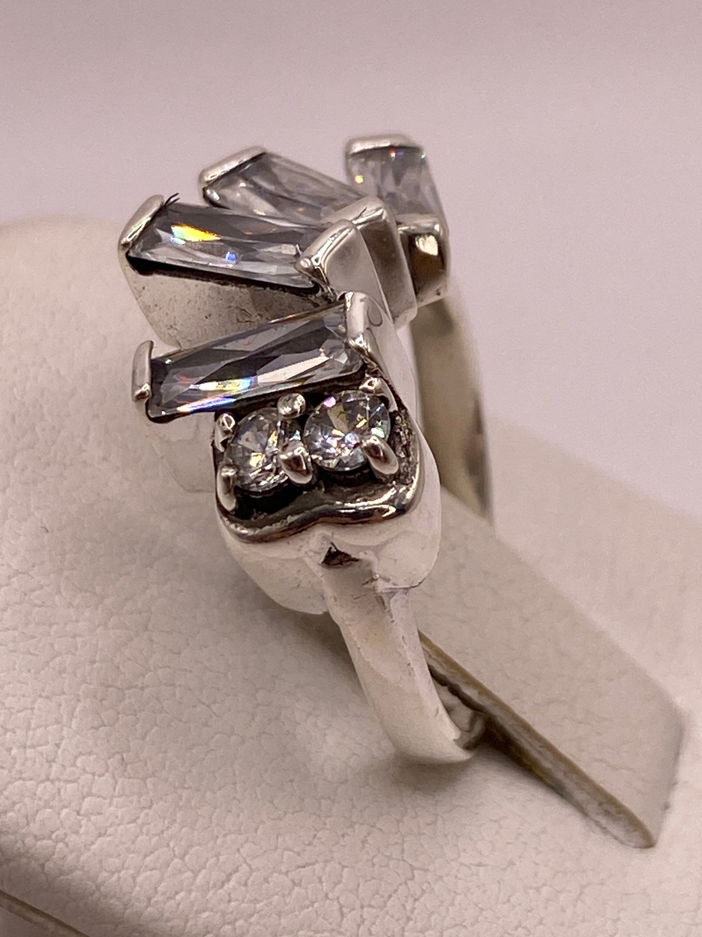 Detalle lateral del engaste a mano de la circonia en banda de plata pulida