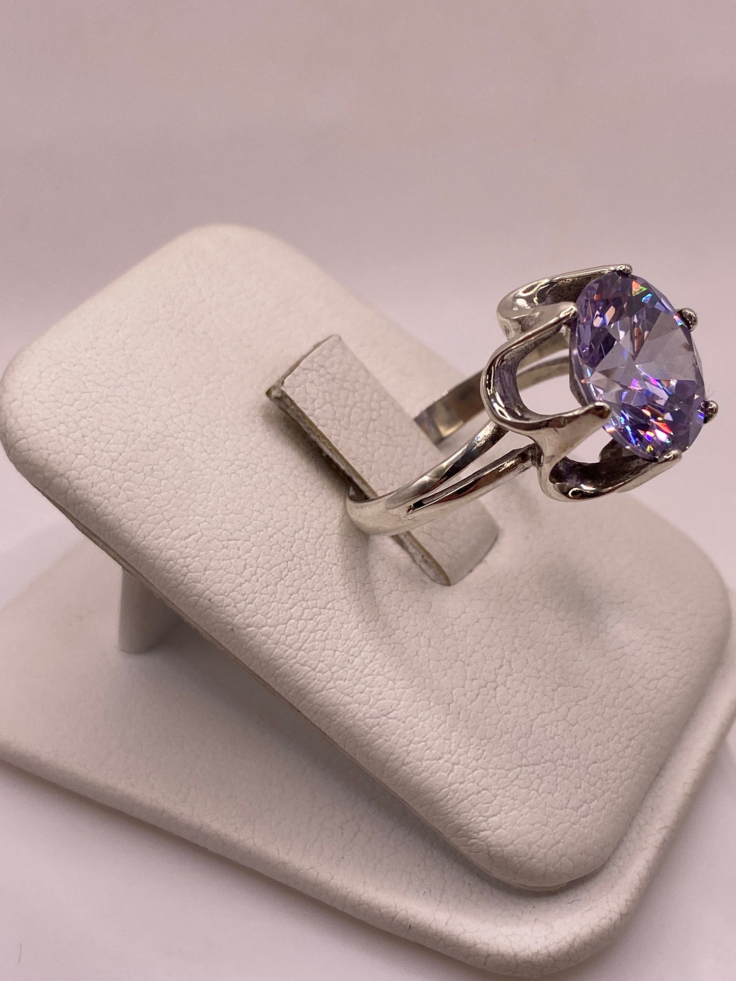 Vista lateral del anillo mostrando la banda de plata y el profundo color violeta de la piedra