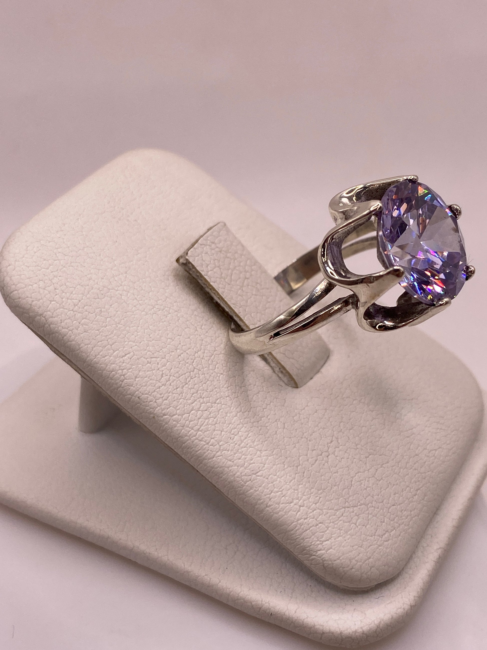 Vista lateral del anillo mostrando la banda de plata y el profundo color violeta de la piedra