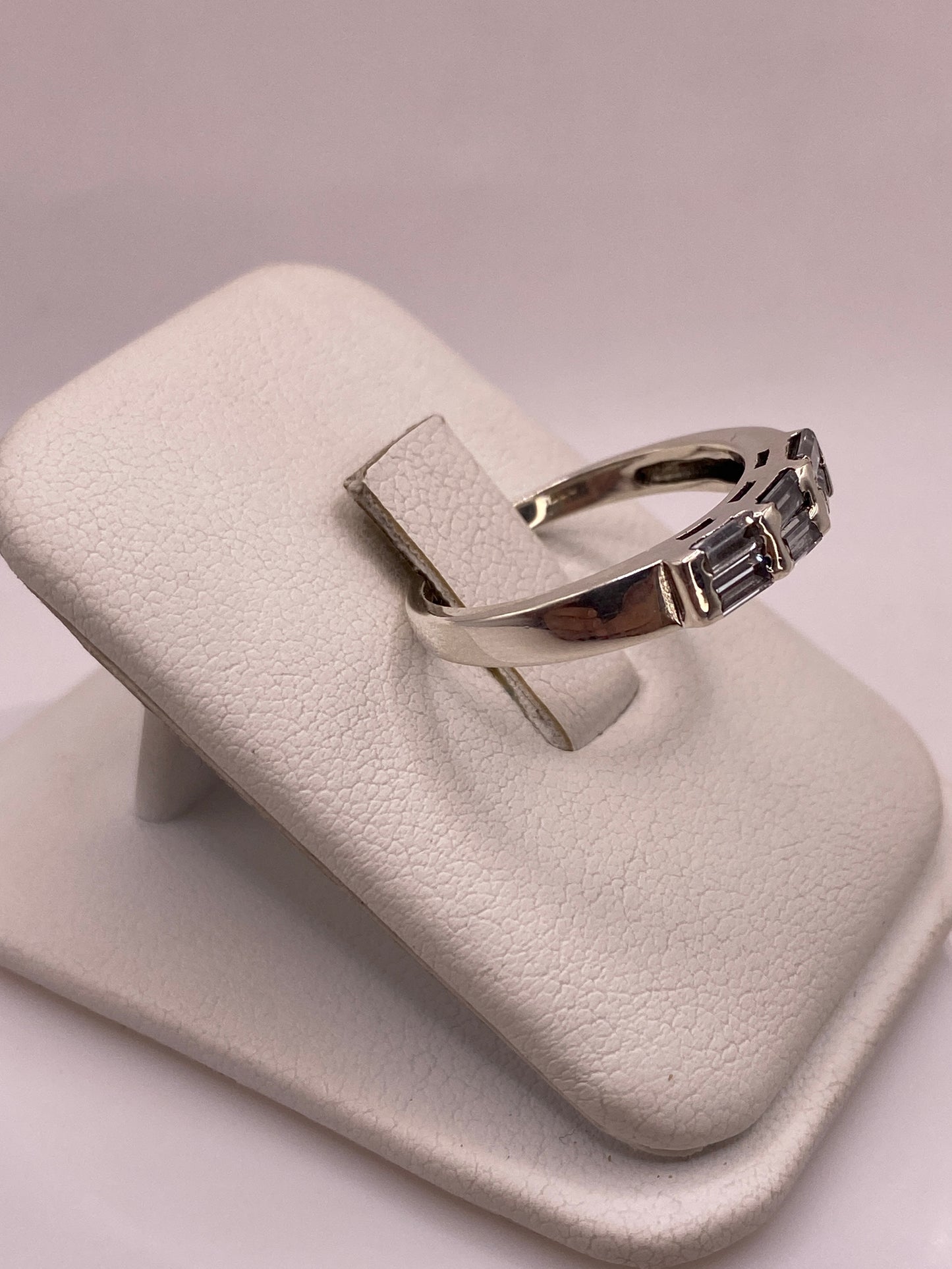 Anillo minimalista de plata pura con circonia, visto desde el costado sobre dedo