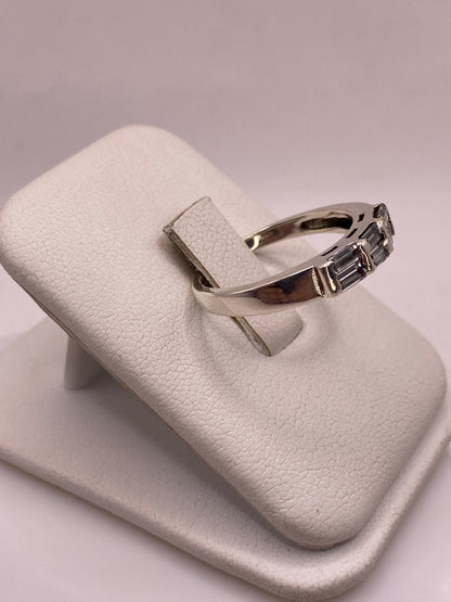Anillo minimalista de plata pura con circonia, visto desde el costado sobre dedo
