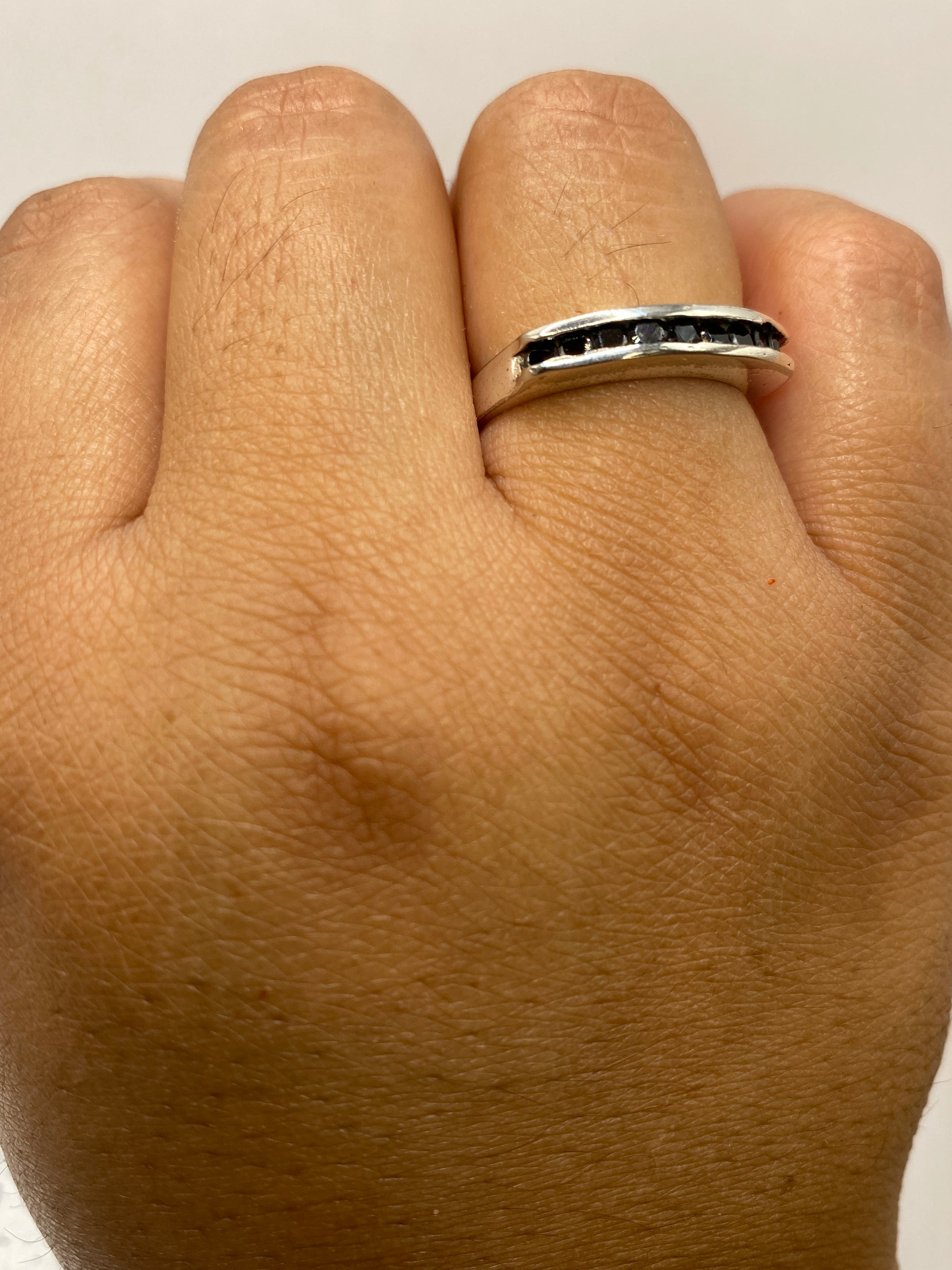Anillo sobre fondo blanco mostrando el sello 925 y la construcción artesanal del engaste