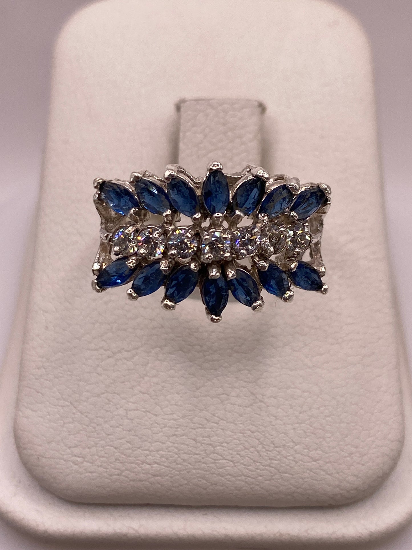 Anillo de plata con racimo de circonias azules y blancas en caja blanca, vista superior