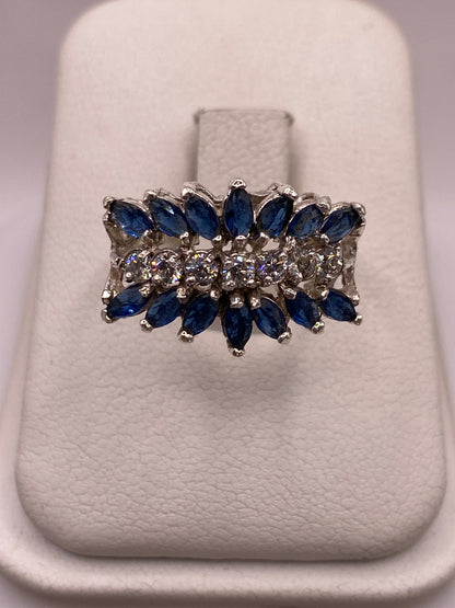 Anillo de plata con racimo de circonias azules y blancas en caja blanca, vista superior