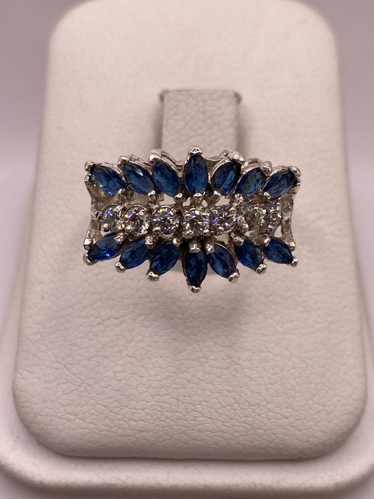 Anillo de plata con racimo de circonias azules y blancas en caja blanca, vista superior