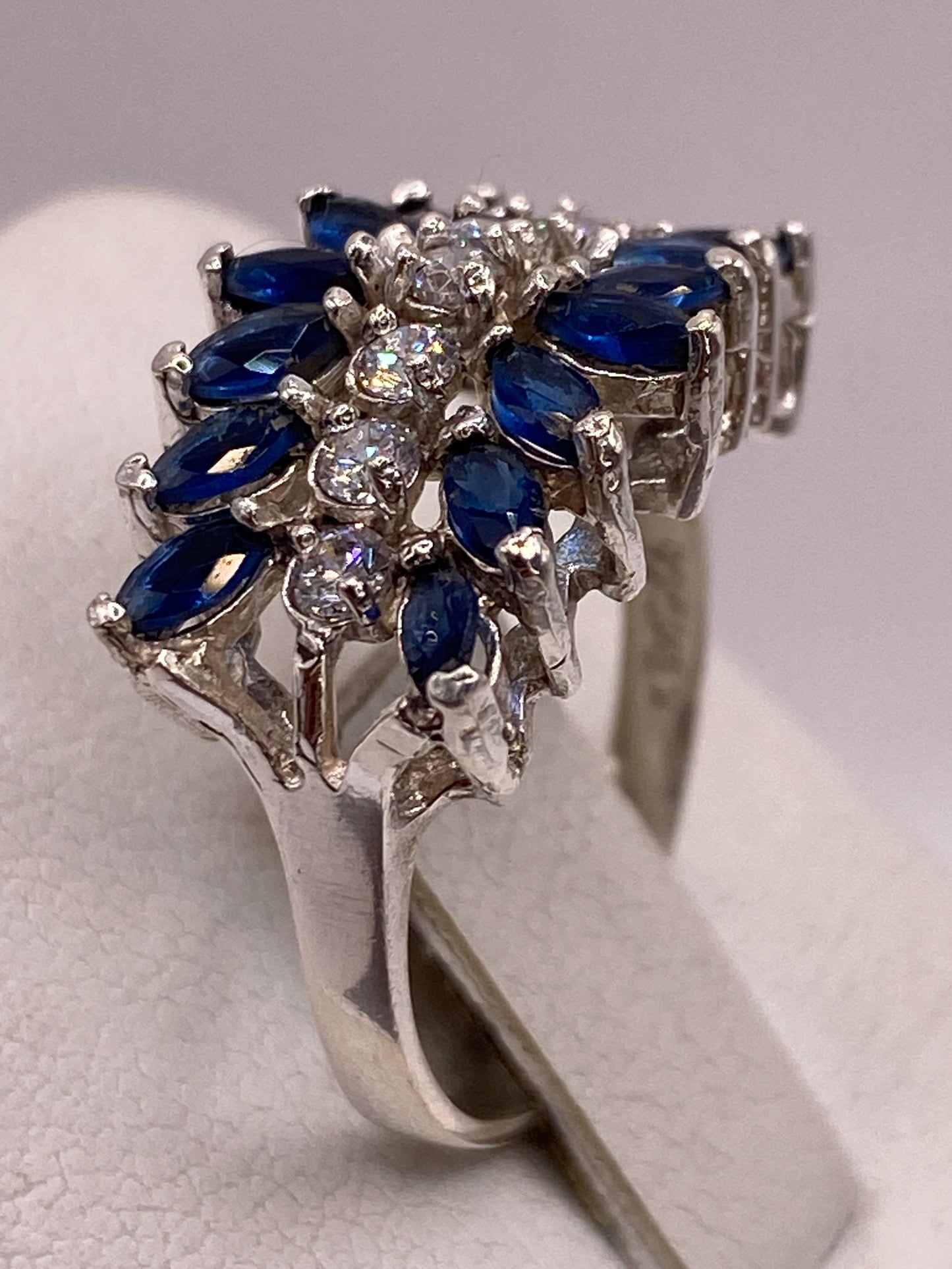 Detalle del engaste de circonias azules en plata pulida, brillo de coctel