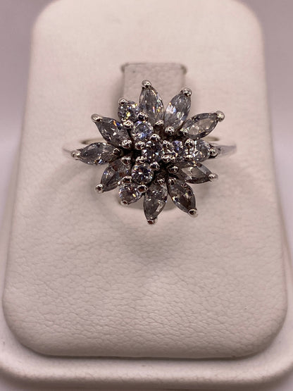 Anillo de plata con flor de circonias blancas visto de frente mostrando el engaste radial