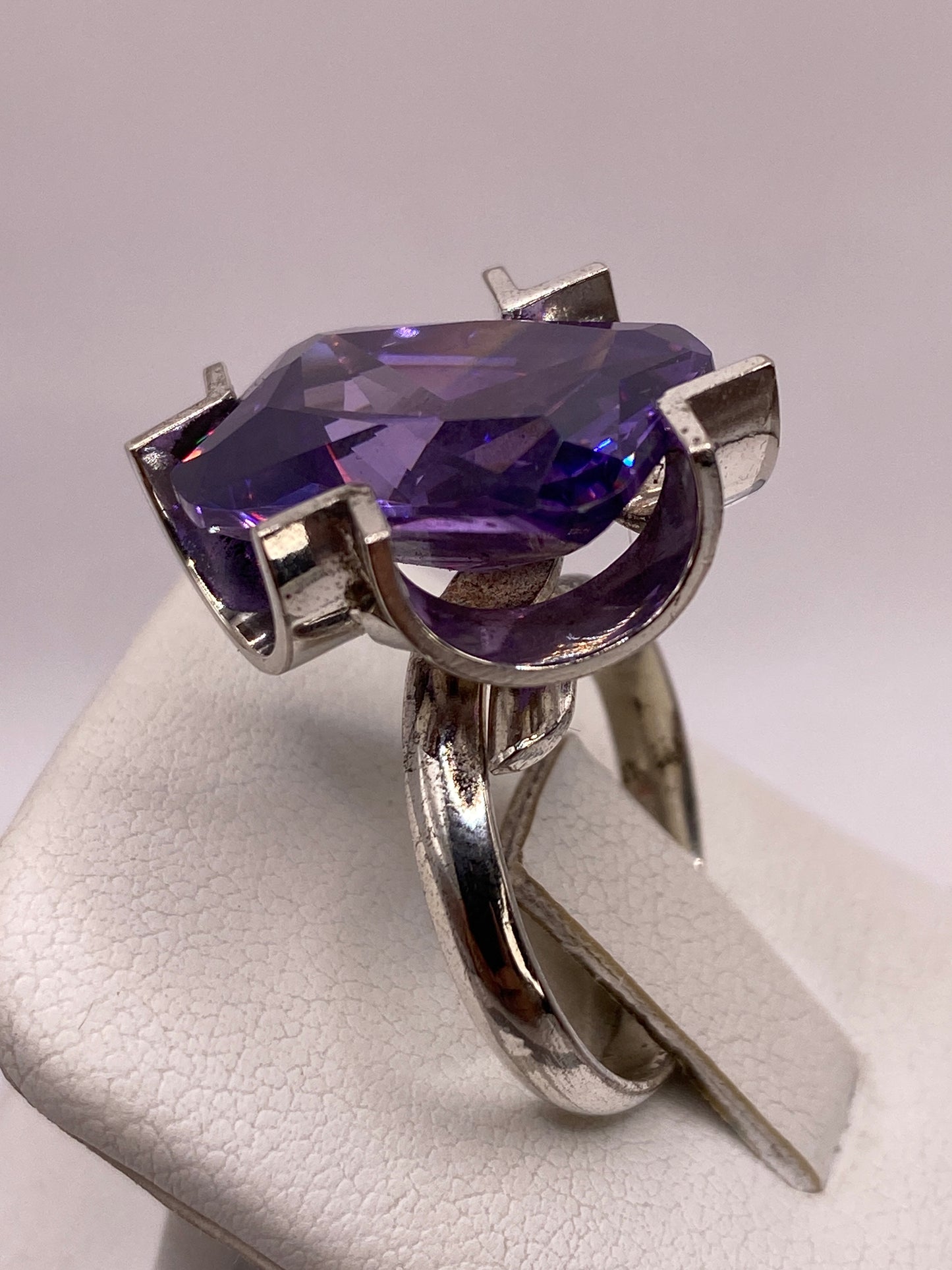 Anillo ajustable de plata con circonia púrpura en la mano mostrando el color intenso