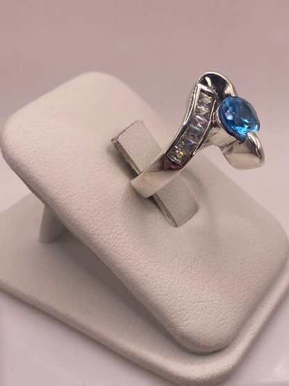 Detalle lateral del anillo mostrando la banda pulida y las alas de plata