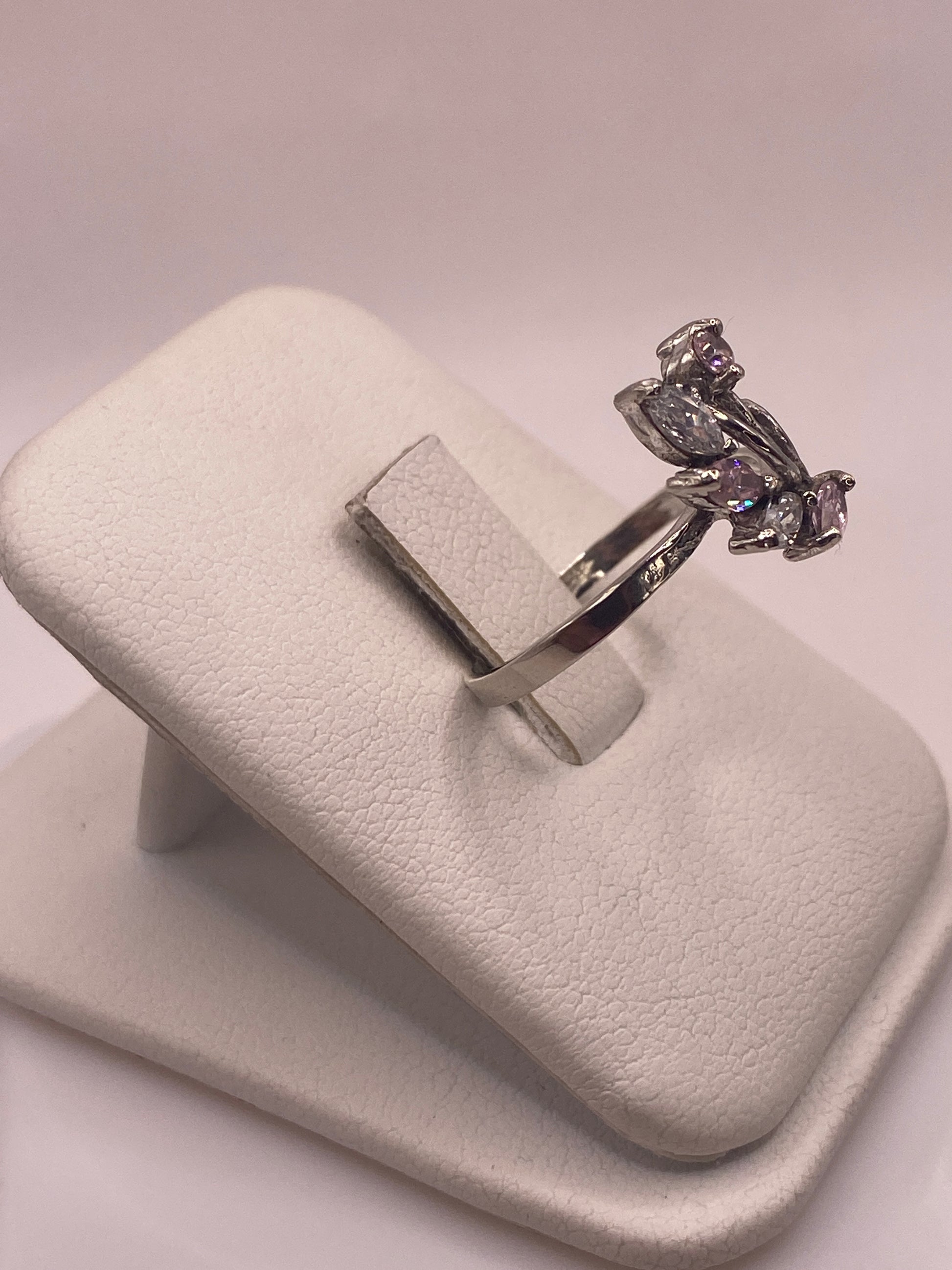 Detalle lateral del anillo con piedra rosa que brilla como diamante