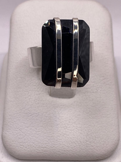 Anillo de plata con circonia negra grande, frente rectangular, sobre blanco
