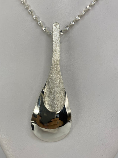 Dije de plata 925 pulido en forma de gota, 6 cm de largo, sostenido en la mano