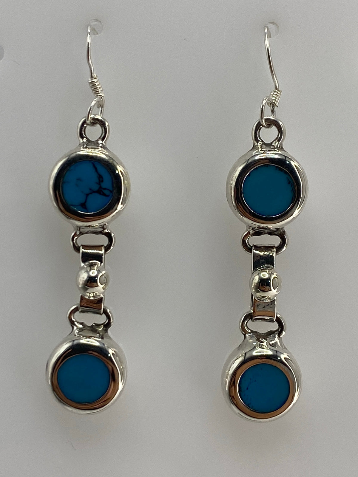 Par de aretes de plata con turquesa azul engastada, 4.9 cm de largo, sobre fondo blanco