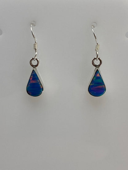 Detalle del ópalo de fuego azul en el arete, mostrando las vetas de color iridiscente