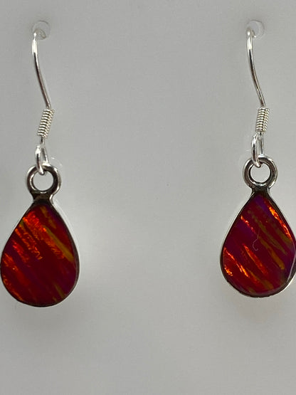 Aretes en las orejas, ópalo de fuego reflejando luz