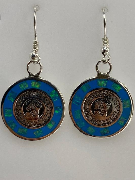 Aretes de plata con ópalo de fuego azul engastados a mano, vistos de frente mostrando el color azul profundo
